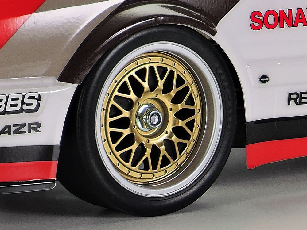 Wheels use slick tyres with gold spokes and silver rims.
