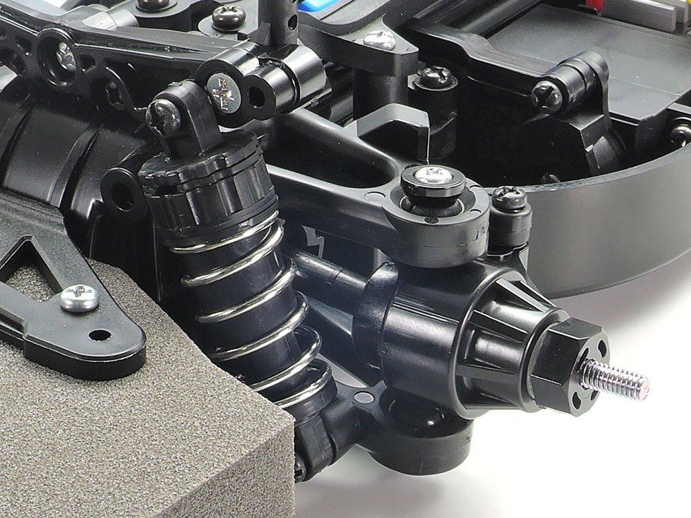 A close-up on the front double-wishbone suspension, which offers a ground-hugging drive. The big bumper helps protect the chassis and body.